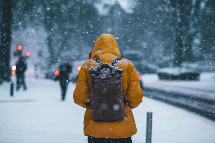 The person in the snow is facing the opportunity cost of not being indoors. The value of being indoors is the warmth and comfort that it provides. The person in the snow is giving up this value when he needs to go somewhere.